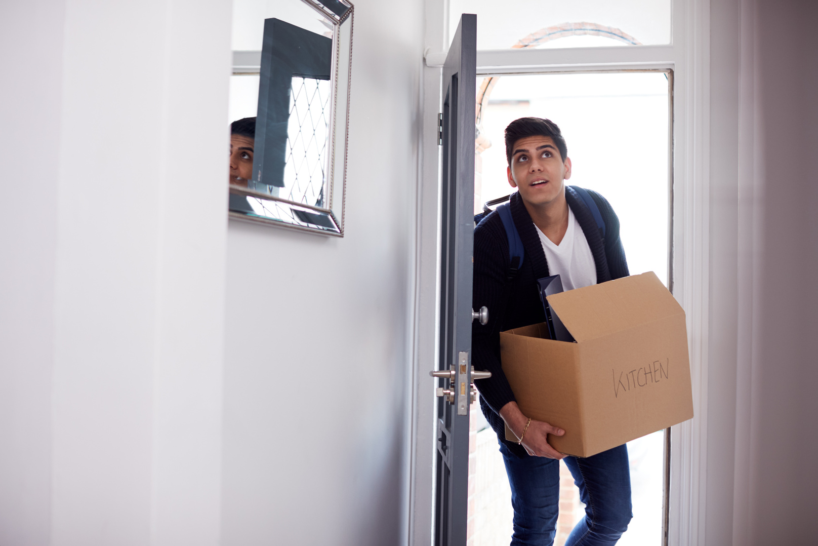 Male College Student Carrying Box Moving into Accommodation
